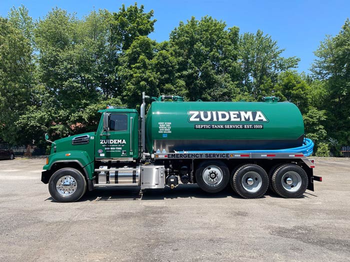 green Zuidema septic truck by woods