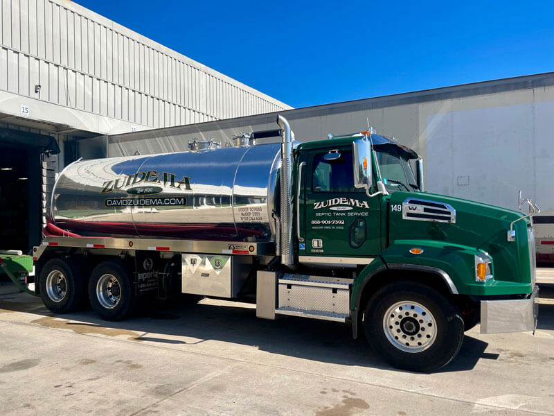 green and silver Zuidema septic truck